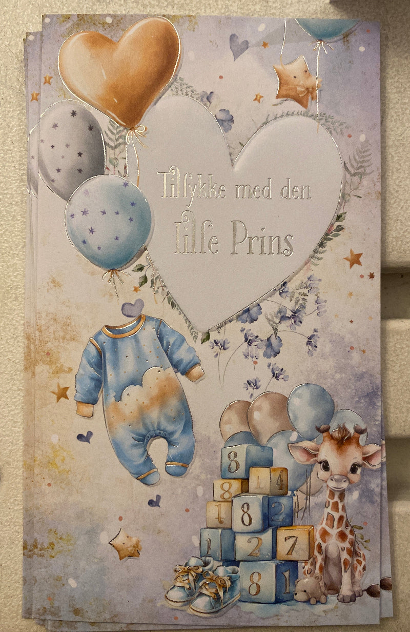 Kort til baby dreng – Tillykke med den lille prins
Blåt kort med motiv af sparkedragt, balloner, klodser og giraf. Tekst: “Tillykke med den lille prins”.
Måler 9,6 x 17,4 cm og leveres med kuvert – perfekt til barselsgave eller dåb.