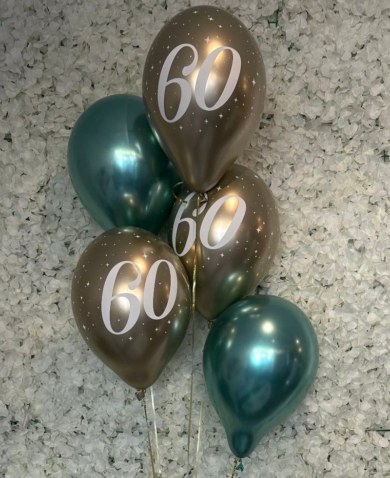 Send en ballonbuket til 60-års fødselsdag! 3 latexballoner i guld med tallet 60 + 2 i valgfri farve. Leveres med helium i kasse – klar til at svæve op.